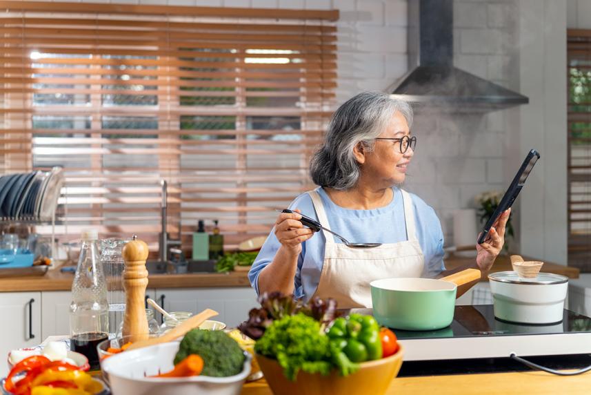 A woman cooking with bowls of vegetables on the counter