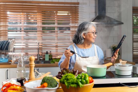 A woman cooking with bowls of vegetables on the counter